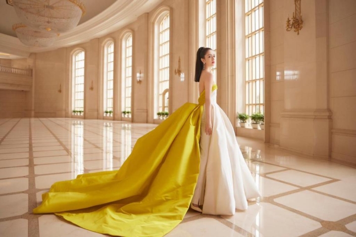Tong Lo Ya wears a yellow and white dress made by Ashi